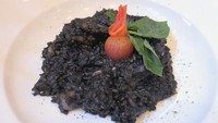 Squid Ink Risotto (Rp 79.500) adalah risotto dengan saus hitam dari tinta cumi. Disajikan bersama udang, ikan gindara dan tomat.