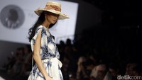 Aksi seorang model memamerkan busana di atas catwalk.