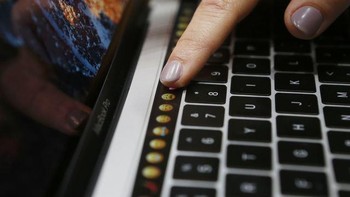 Mencoba menekan emoji di touch bar MacBook baru. Foto: Getty Images