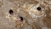 Anak-anak berenang di Kali Inspeksi Ciliwung.