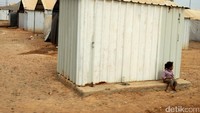 Seorang anak duduk termenung di depan tenda pengunsian.