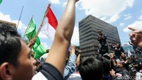 Agus yang mengenakan baju tacticool warna hitam naik ke atap mobil untuk menyapa pendukungnya.