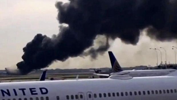 Asap hitam pekat membubung dari badan pesawat yang terbakar