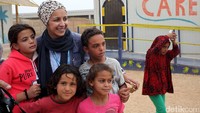 Petugas dari UNHCR foto bersama beberapa anak pengungsi.