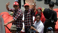 Pasangan Ahok dan Djarot mengikuti pawai dengan mengenakan kemeja kotak-kotak dan topi warna merah. Truk yang digunakan untuk pawai juga bermotif kotak-kotak.