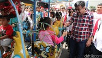 Cawagub Djarot menyapa anak-anak yang sedang naik odong-odong di Festival Budaya Betawi Pecenongan.
