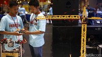 Dua orang peserta mempersiapkan robot yang akan ditampilkan di kompetisi Robotik Madrasah 2016.