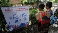 2 Orang anak melihat spanduk Anies-Sandi.