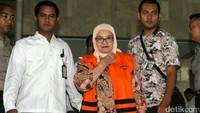 Siti berjalan meninggalkan gedung KPK.
