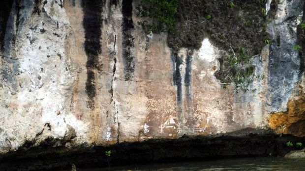 Penampakan lukisan purba di Teluk Kabui dari kejauhan (Wahyu/detikTravel)