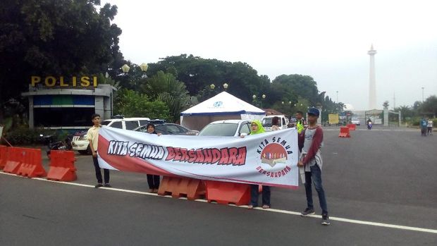 Warga Bagikan Stiker 'Kita Semua Bersaudara' di Patung Kuda