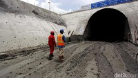 Dua orang pekerja melintas di terowongan yang masih dalam tahap pembangunan.