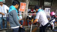 Pendemo menyapu sampah di sekitar Istiqlal.