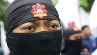 Salah seorang pendemo mengenakan penutup wajah.