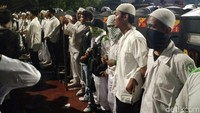 Massa FPI bergandengan tangan, seolah menjadi tameng bagi polisi.