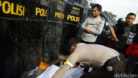 Aksi simpatik dilakukan oleh seorang personel polisi, dihadapan peserta demo yang sedang salat polisi tersebut memberikan kain putih sebagai sajadah.