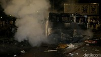 Mobil yang dibakar masih mengepulkan asap.
