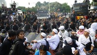Sejumlah personel gabungan Polri dan TNI duduk bersama para pendemo 4 November di depan Istana.