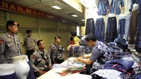 Beberapa polisi berbincang dengan pedagang. Hari ini pengelola gedung Pasar Tanah Abang menginstruksikan para pemilik toko tutup pada pukul 11.00 WIB.