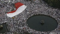 Ditengah lautan pendemo, bendera Merah Putih raksasa mulai diarak.