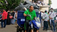 Sampah dibuang menggunakan motor.