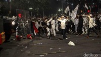 Demonstran memukul barracuda dengan bambu.