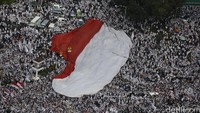 Bendera raksasa itu diarak para pendemo menuju Istana.