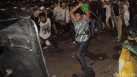 Beberapa demonstran menyerang polisi dengan bambu.