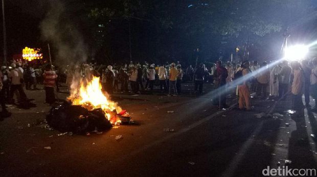  Massa membuat kobaran api dengan membakar kumpulan sampah di beberapa titik sekitar pukul 20.30 WIB, Jumat (4/11/2016)