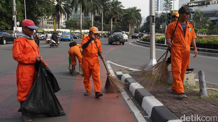 Sejumlah Pasukan Oranye tengah membersihkan sampah yang berada di Bundaran HI pasca sejumlah demonstran melewati kawasan tersebut.