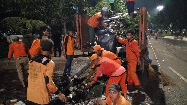 Petugas Kebersihan Bergelut dengan Sampah di Taman Jalan Monas 
