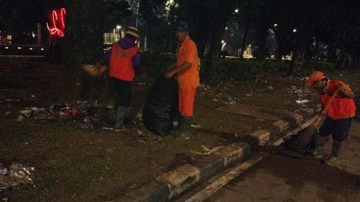 Petugas Kebersihan Bergelut dengan Sampah di Taman Jalan Monas