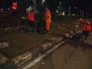 Petugas Kebersihan Bergelut dengan Sampah di Taman Jalan Monas