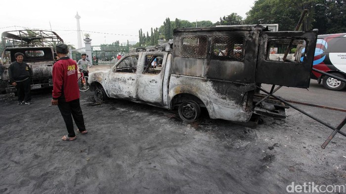Cheese! Warga Berfoto dengan Background Bangkai Mobil Kerusuhan 4 November