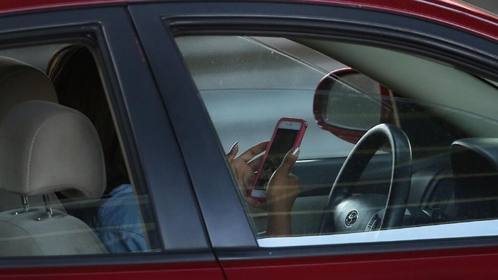 NEW YORK, NY - APRIL 30: A driver uses a phone while behind the wheel of a car on April 30, 2016 in New York City. As accidents involving drivers using phones or other personal devices mount across the country, New York lawmakers have proposed a new test called the Textalyzer to help curb mobile phone usage behind the wheel. Similar to a Breathalyzer test, the Textalyzer would allow police to request phones from drivers involved in accidents and then determine if the phone had been used while the drivers operated their vehicles. The controversial bill is currently in the early committee stage. According to statistics, In 2014 431,000 people were injured and 3,179 were killed in car accidents involving distracted drivers. (Photo by Spencer Platt/Getty Images)