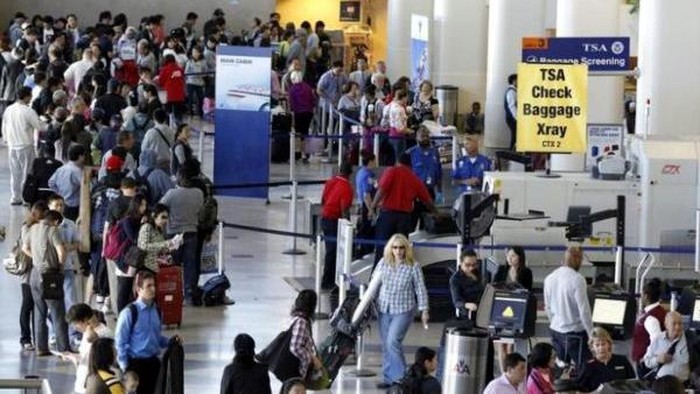 A TSA check baggage X-ray machine is seen in terminal 4 at LAX, Los Angeles International Airport, as travelers wait in a ticketing line in Los Angeles May 2, 2011. REUTERS/Danny Moloshok