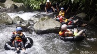Traveler asyik bermain river tubing.