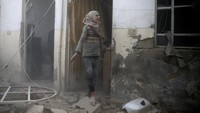 Gadis itu berdiri di depan rumahnya yang telah hancur. REUTERS/Bassam Khabieh.