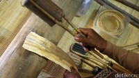 Memukul kayu dengan menyesuaikan serat supaya tidak pecah.