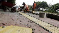 Pekerja sedang mengerjakan pembuatan trotoar di kawasan Matraman, Jakarta Timur.