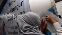 Seorang pengunjung mempersiapkan CV nya.