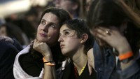 Seorang ibu nampak merangkul sang anak yang nampak sedih karena perolehan suara Hillary tertinggal dari Trump. REUTERS/Carlos Barria.