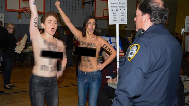 Dua demonstran wanita yang bertelanjang dada beraksi di tempat Trump memilih