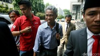 Buni yang mengenakan kemeja lengan panjang memasuki kantor Bareskrim.