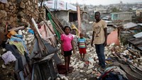 Prenille Nord bersama dua anaknya Daeline dan Kervins berdiri diantara puing-puing rumah mereka yang hancur. Rumah saya hancur, saya takut kolera, saya benar-benar membutuhkan bantuan. sejauh ini kami belum menerima bantuan apapun, tegas Nord. REUTERS/Carlos Garcia Rawlins.