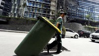 Petugas kebersihan melintas di depan Apartemen Neo Soho.