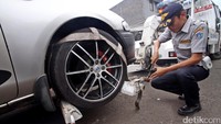 Petugas Dishub menderek mobil yang parkir sembarangan.