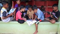 Anak-anak asyik membaca.