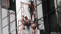 Sejumlah pekerja mengecat tembok gedung bertingkat di Jakarta, Selasa (15/11/2016).
