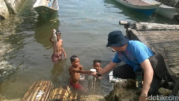 Foto: Turis domestik saja penasaran ingin memegang gurita yang mereka tangkap. Karena ukurannya tidak kecil (Bona/detikTravel) Foto: Turis domestik saja penasaran ingin memegang gurita yang mereka tangkap. Karena ukurannya tidak kecil (Bona/detikTravel)